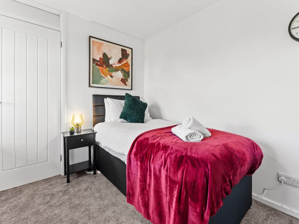 A bedroom with a bed and bedside table at Edison House Stafford