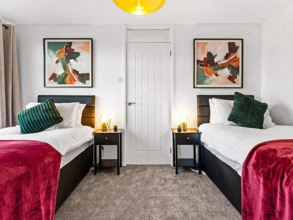 A bedroom with two beds and artworks on the wall at Edison House Stafford