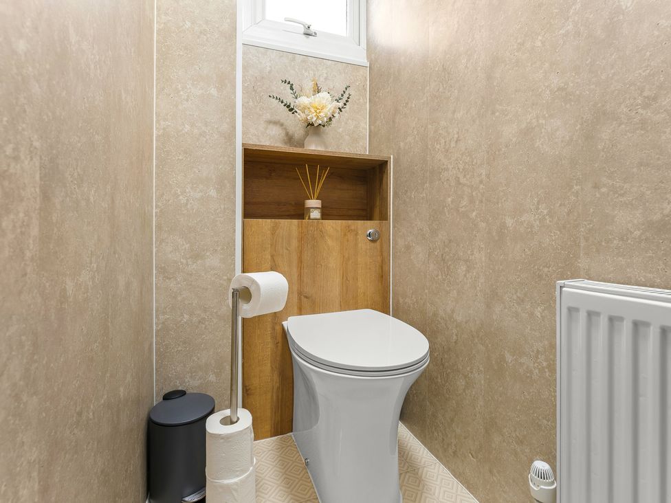 A bathroom with a toilet and shelf at Edison House Stafford