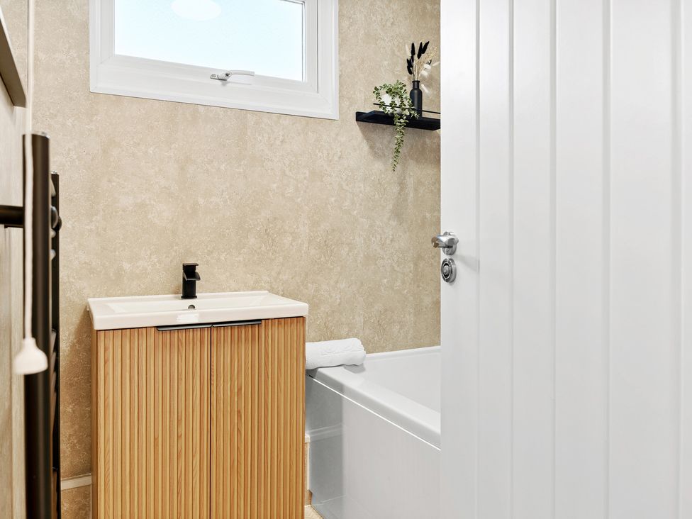 A bathroom with sink and bath tub at Edison House Stafford