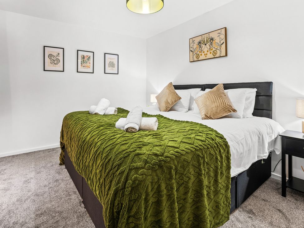 A bedroom with a bed and decorative pillows at Edison House Stafford