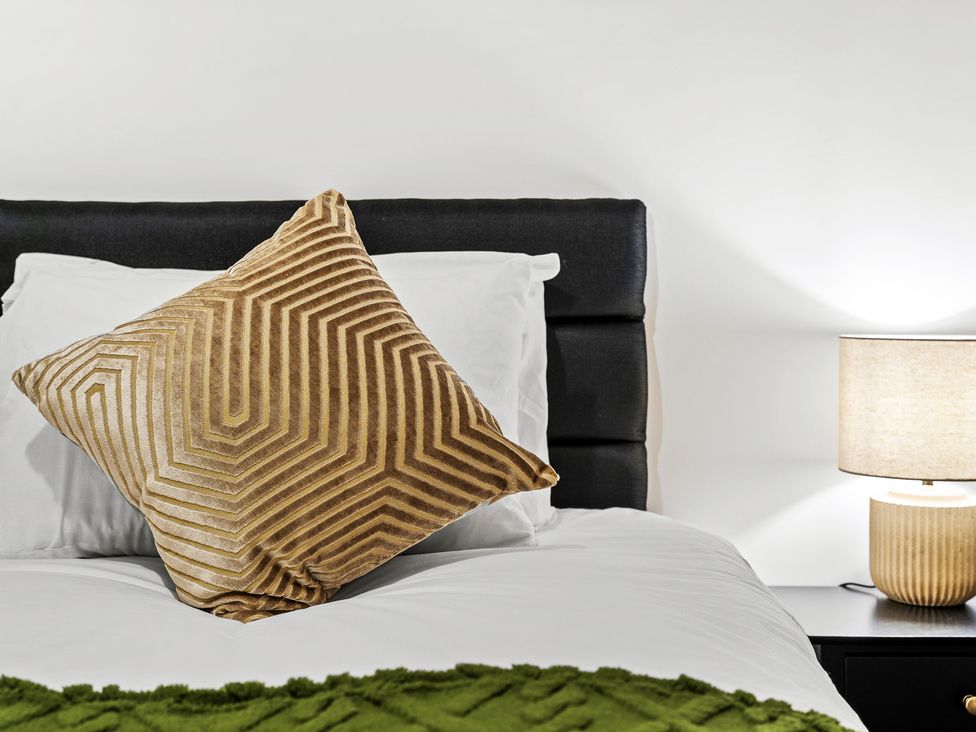 A bedroom with a pillow and lamp on the bedside table at Edison House Stafford