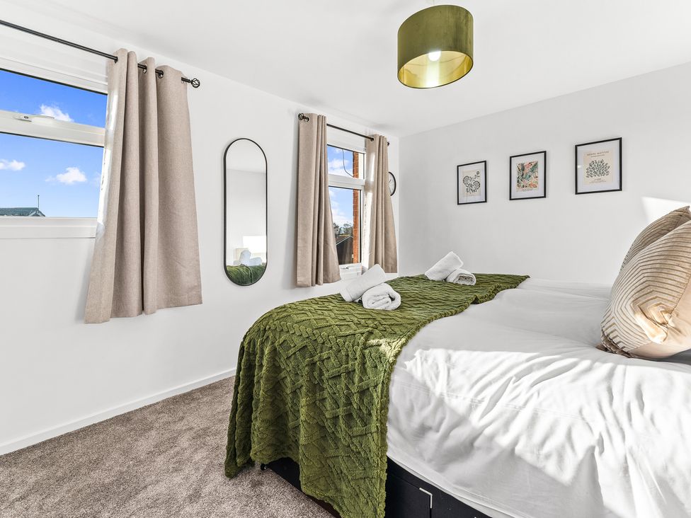 A bedroom with a bed and artwork on the walls at Edison House Stafford