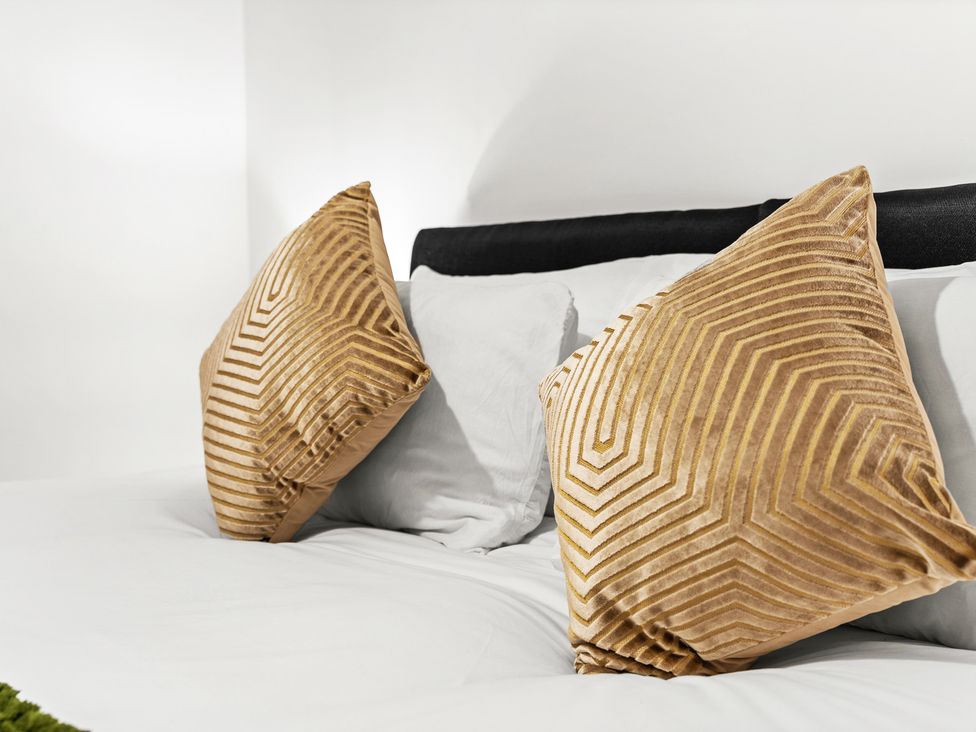 A bed with throw pillows at Edison House Stafford
