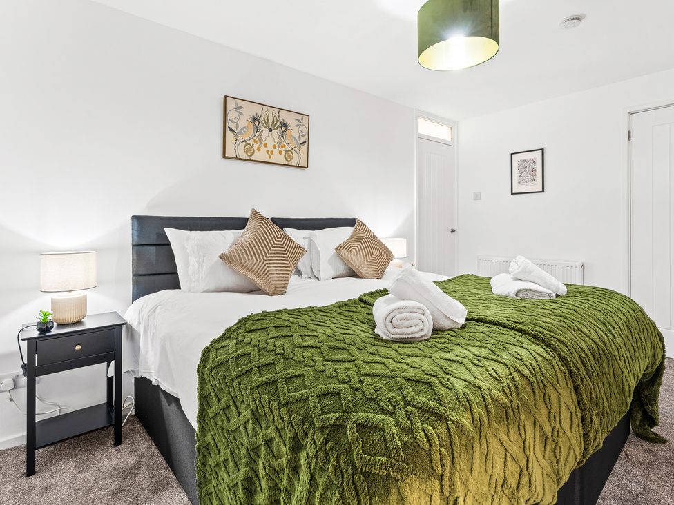 A bedroom with two beds and decorative items at Edison House Stafford