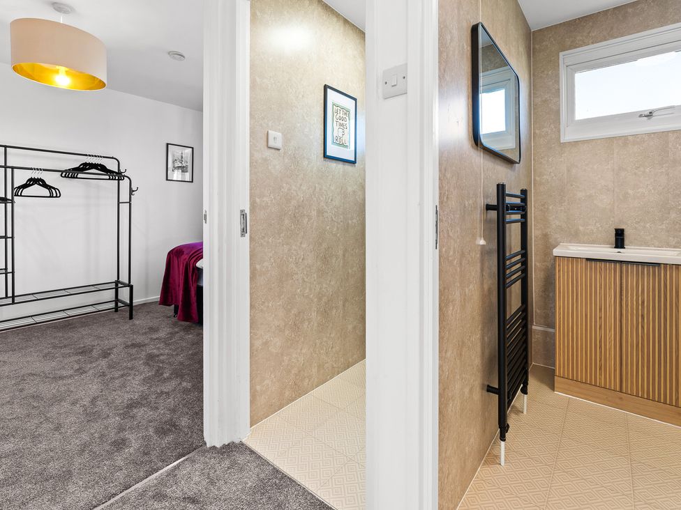 A bathroom with a towel warmer and sink at Edison House Stafford