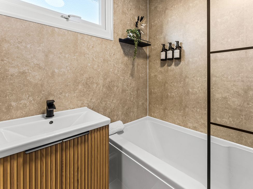 A bathroom with a sink and bathtub at Edison House Stafford