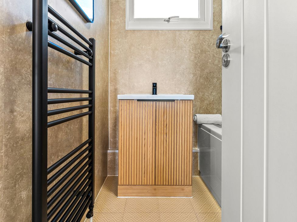 A bathroom with a sink and heated towel rail at Edison House Stafford