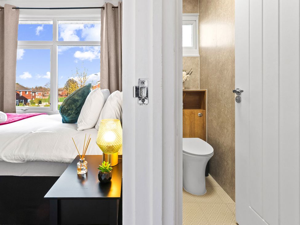 A bedroom with a bed and a bathroom visible at Edison House Stafford