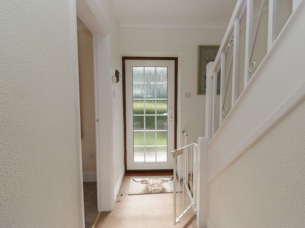 A hallway with a staircase and a doorway at Throstlegarth in Milnthorpe