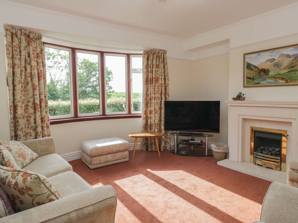 A living room with a television and a fireplace at Throstlegarth in Milnthorpe