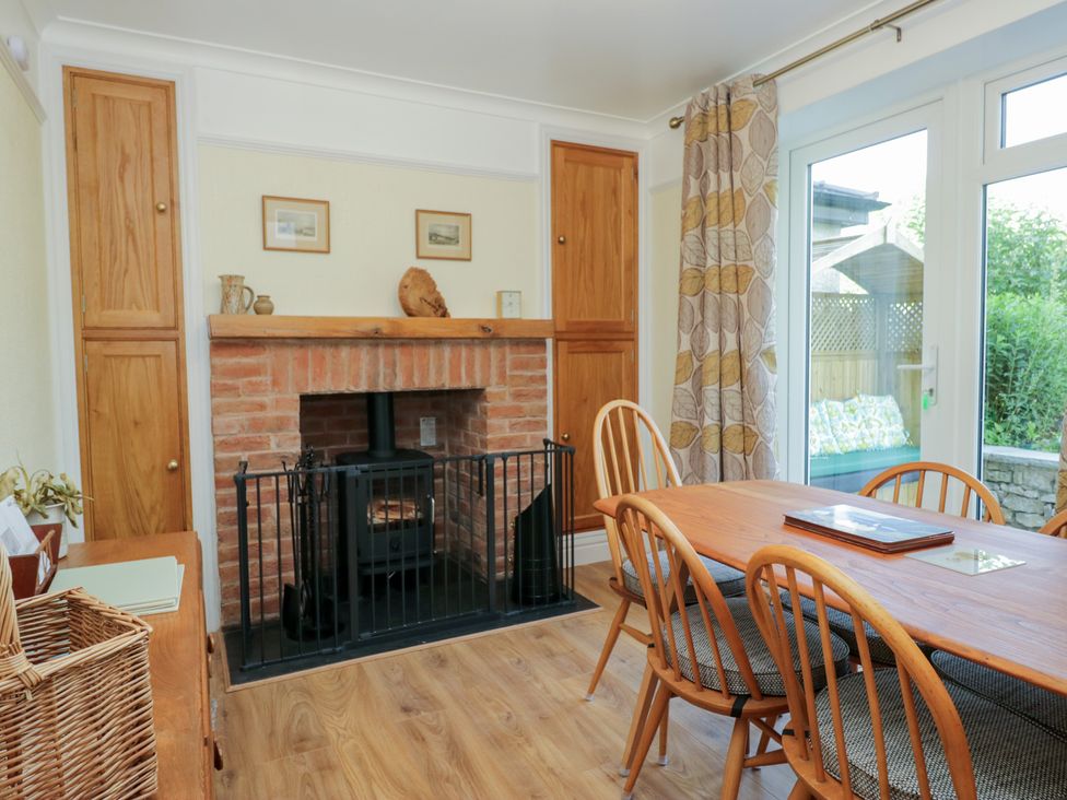 A dining room with a fireplace and dining table at Throstlegarth in Milnthorpe