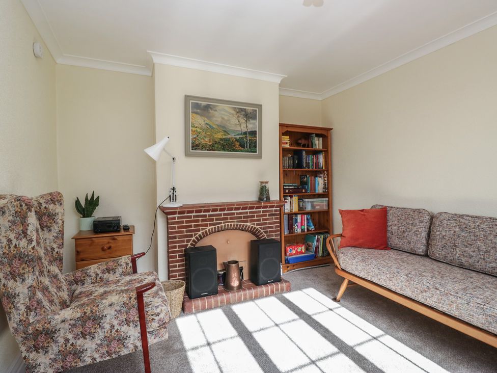 A living room with a sofa and fireplace at Throstlegarth in Milnthorpe