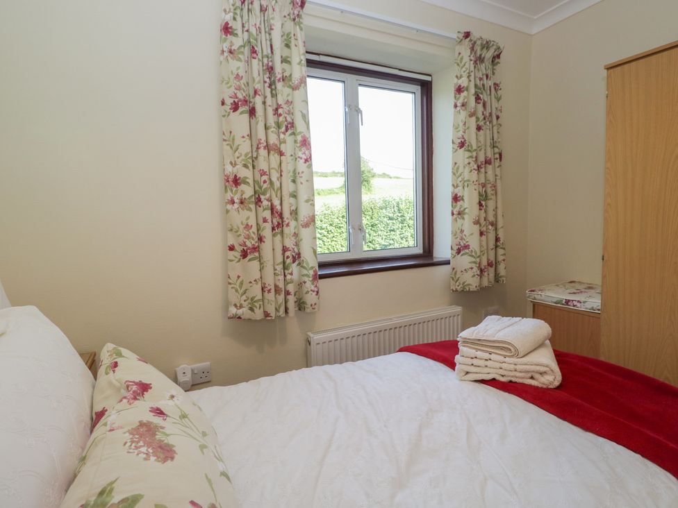 A bedroom with a bed and window at Throstlegarth in Milnthorpe