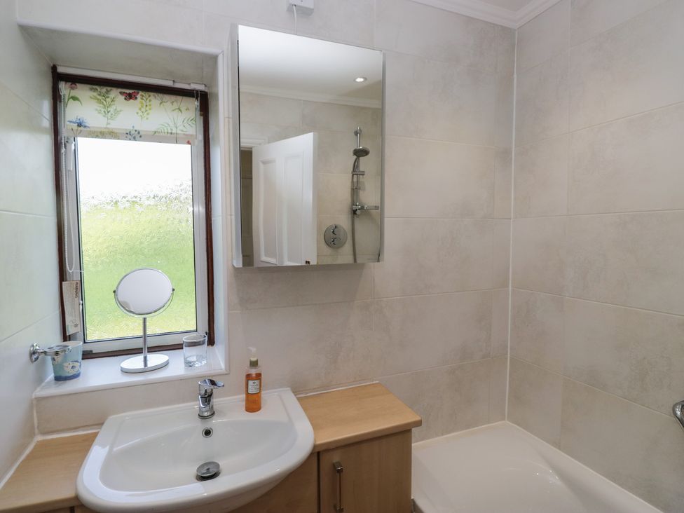 A bathroom with a sink, shower, and bathtub at Throstlegarth in Milnthorpe