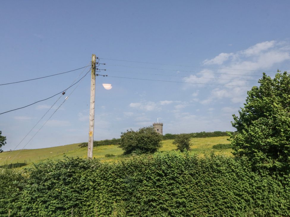 A view of a power pole and a tower in a field at Throstlegarth in Milnthorpe