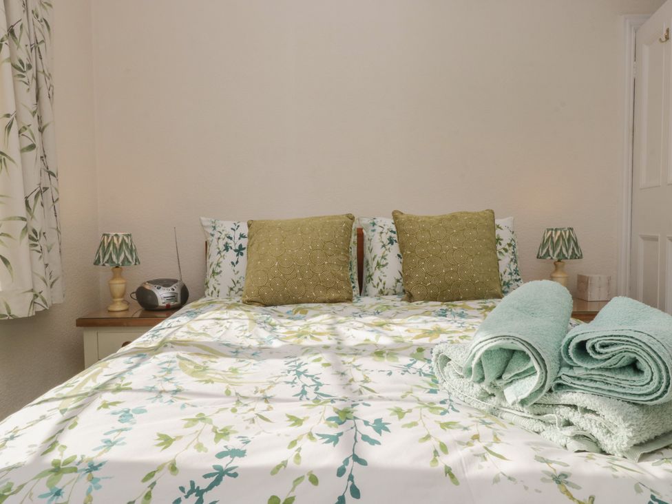 A bedroom with a bed and towels on a bedside table at Throstlegarth in Milnthorpe