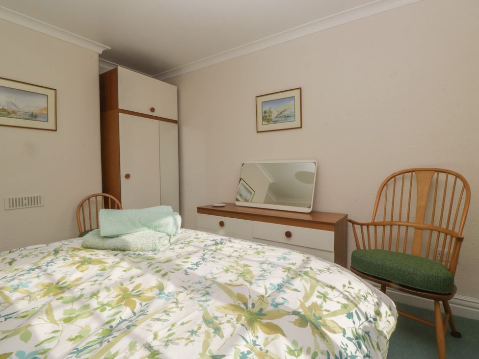 A bedroom with a bed and wardrobe at Throstlegarth in Milnthorpe