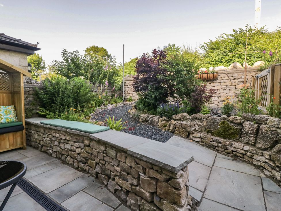 A garden with stone walls and plants at Throstlegarth in Milnthorpe