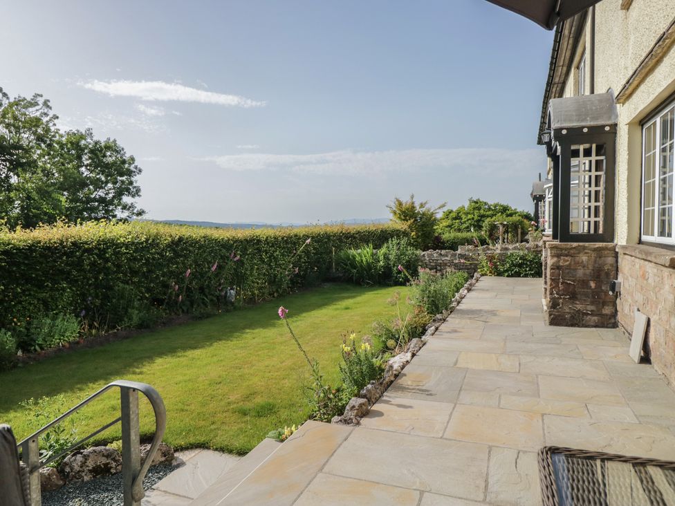 A garden with grass and patio at Throstlegarth in Milnthorpe