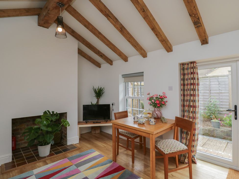 A dining room with a table and chairs at Cosy Cottage in Babbacombe