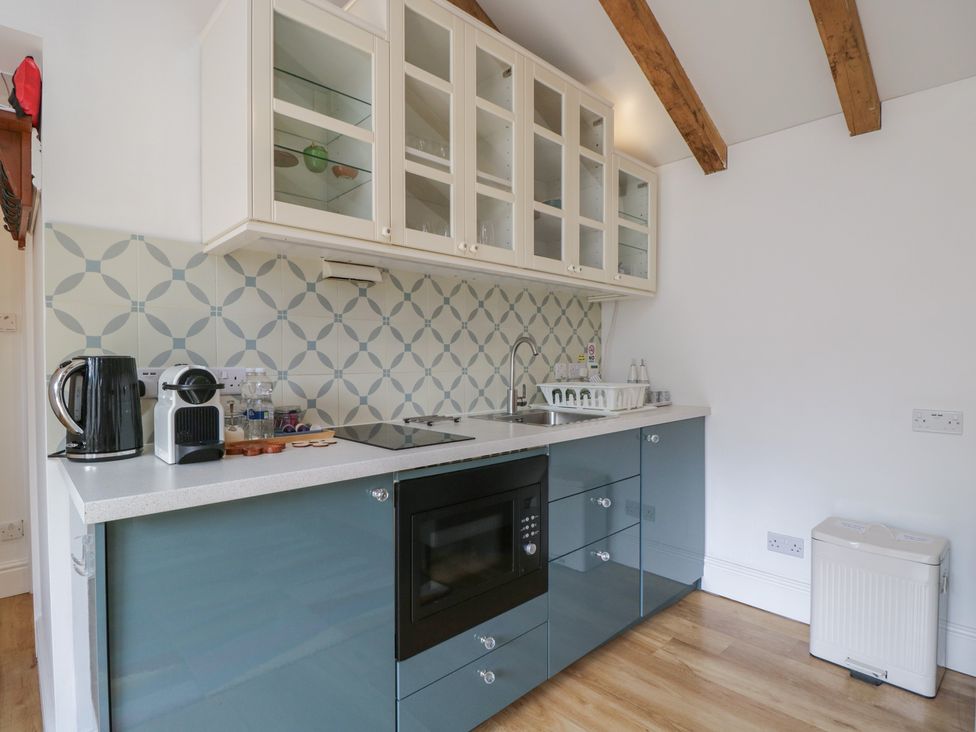 A kitchen with cabinets and appliances at Cosy Cottage in Babbacombe
