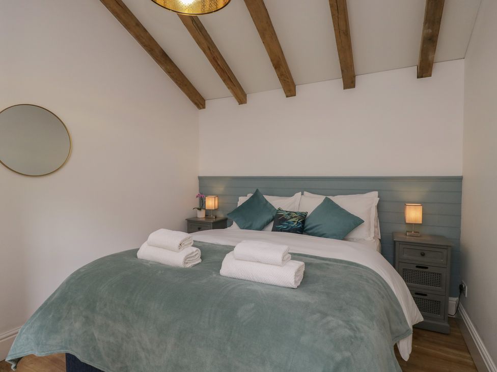 A bedroom with a bed and bedside table at Cosy Cottage in Babbacombe