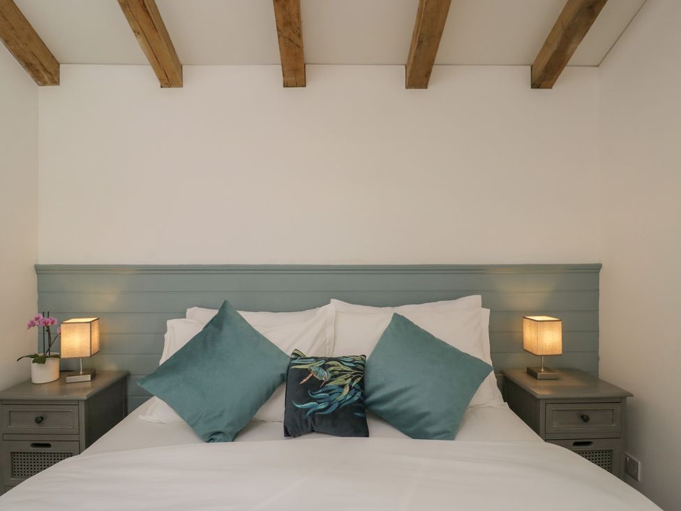 A bedroom with a bed and bedside tables at Cosy Cottage in Babbacombe