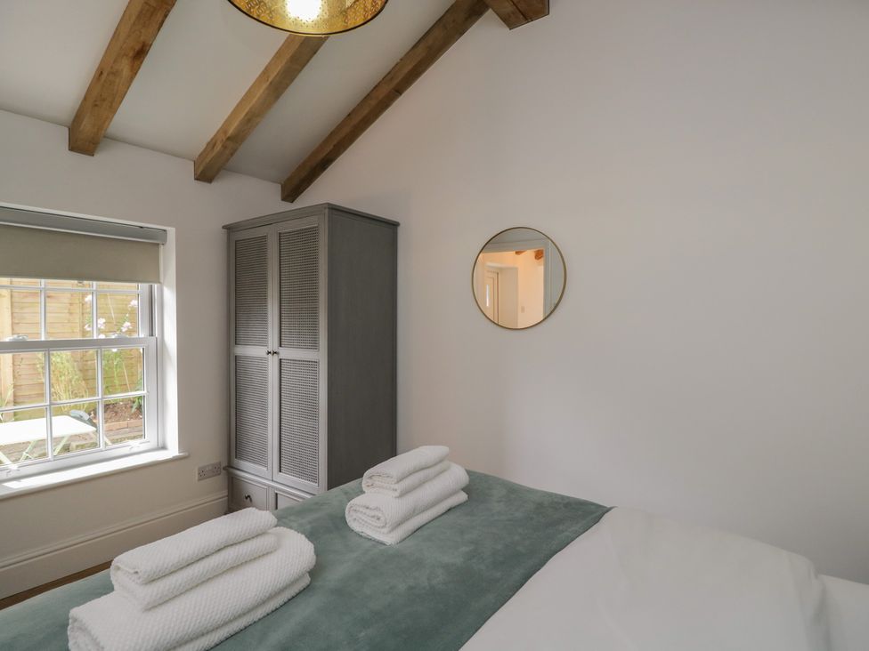 A bedroom with towels on a bed at Cosy Cottage in Babbacombe