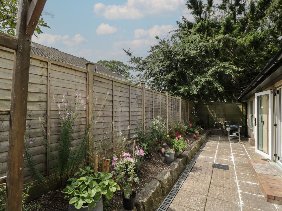 A garden with flowers and a fence at Cosy Cottage in Babbacombe