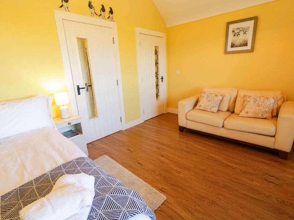 A bedroom with a bed and a sofa at The Mummers Studio Apartment 1, Derrylin, County Fermanagh