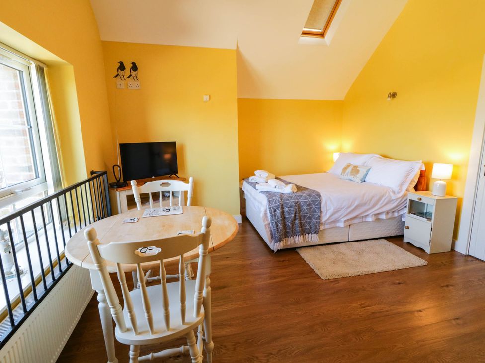 A bedroom with a bed and dining area at The Mummers Studio Apartment 1 in Derrylin, County Fermanagh