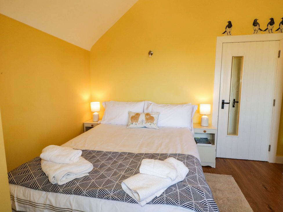 A bedroom with a bed and nightstand at The Mummers Studio Apartment 1 in Derrylin, County Fermanagh
