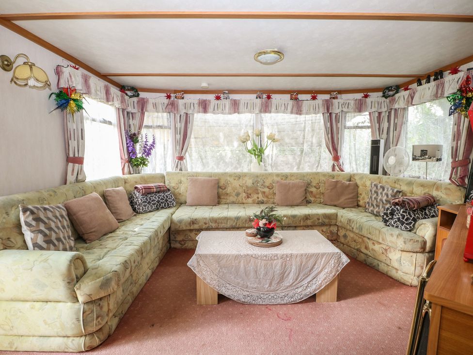 A living room with a sectional sofa and a coffee table at 10 Cater Gardens in Guildford