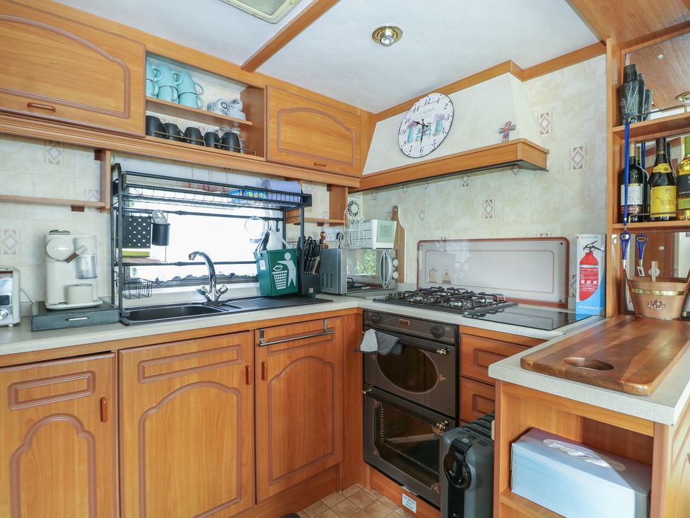 A kitchen with wooden cabinets and appliances at 10 Cater Gardens in Guildford