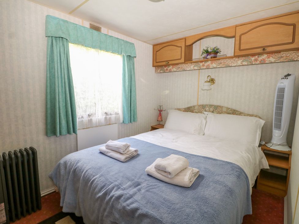 A bedroom with a bed and nightstand at 10 Cater Gardens Guildford