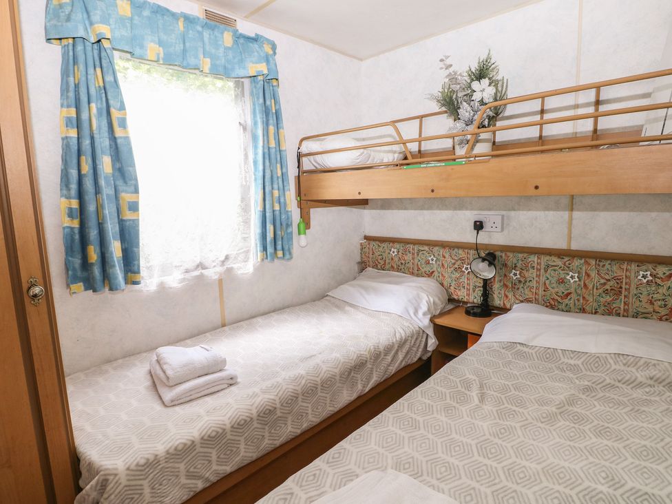 A bedroom with a bunk bed and a single bed at 10 Cater Gardens in Guildford