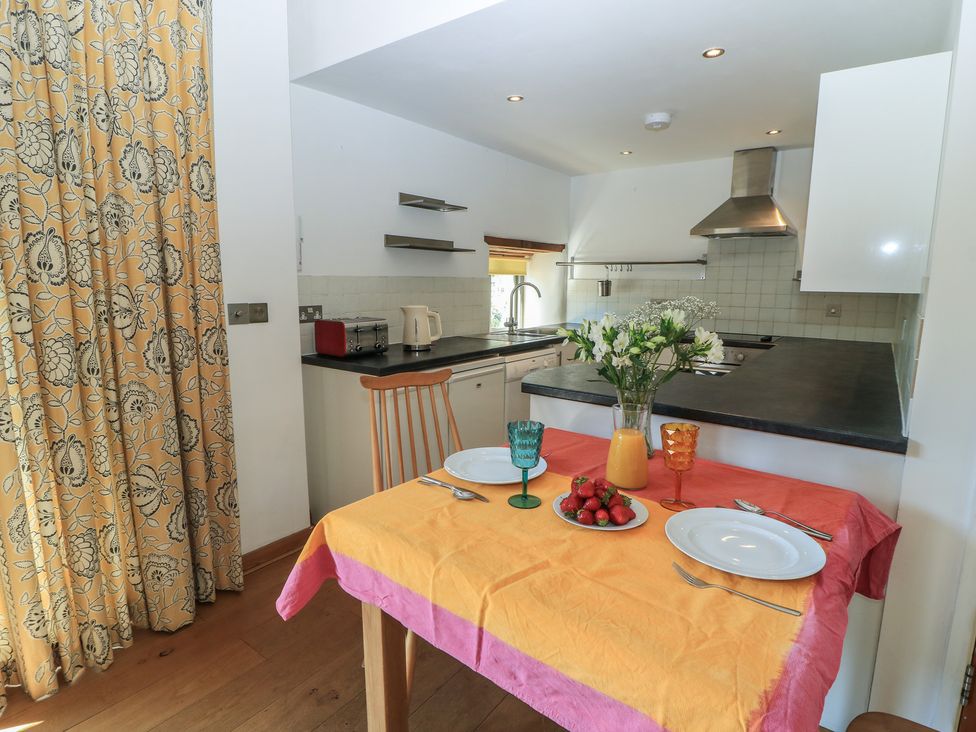 A kitchen with a table set for two at Frome Gazey in Frampton