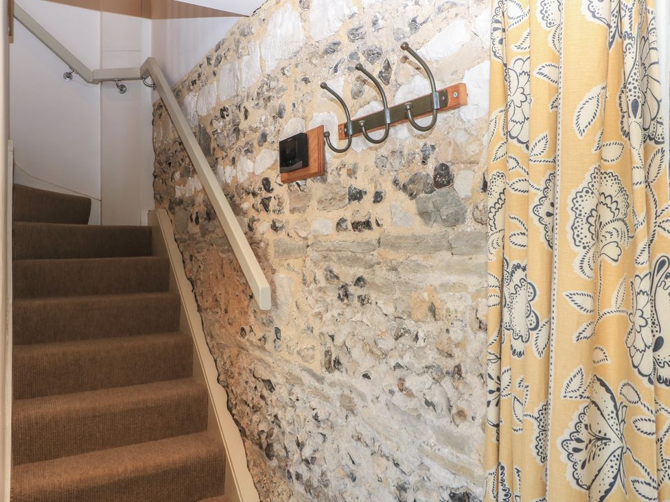 A staircase with a wall and coat hooks at Frome Gazey in Frampton