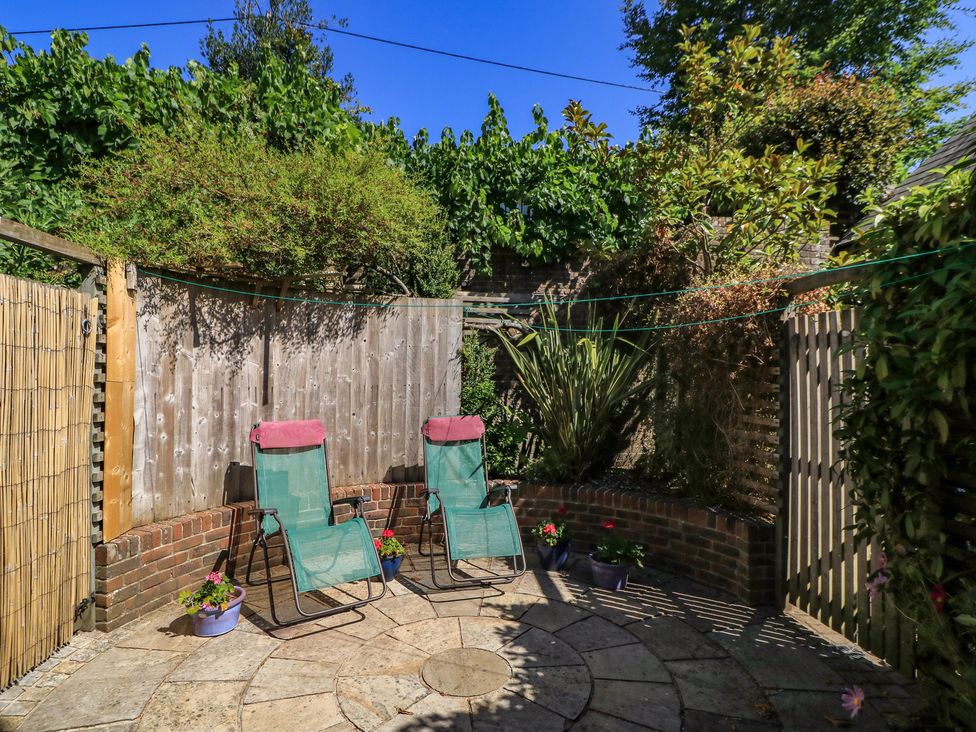 A garden with deck chairs and potted plants at Frome Gazey in Frampton