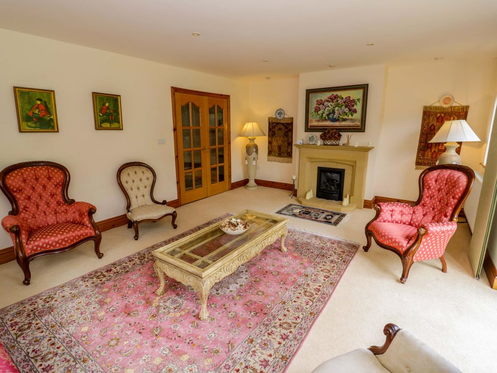 A living room with a sofa and armchairs at Meadow View Bungalow in Droitwich