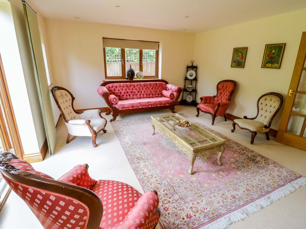 A living room with a sofa and armchairs at Meadow View Bungalow in Droitwich