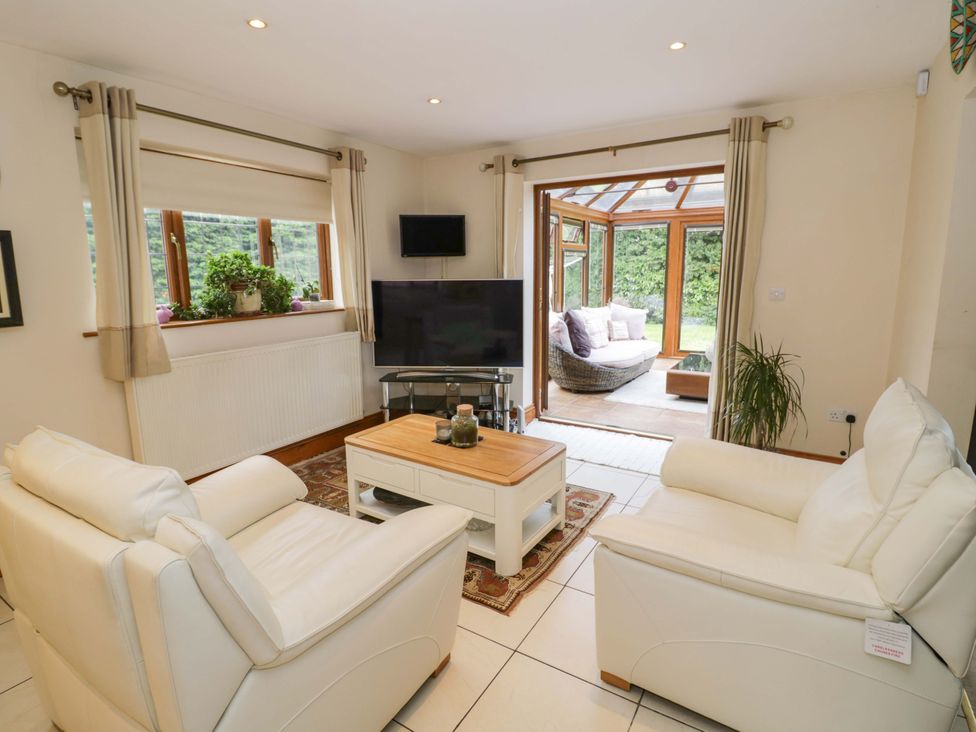 A living room with sofas and a television at Meadow View Bungalow in Droitwich