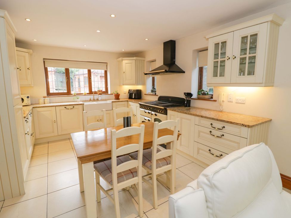 A kitchen with a table and chairs at Meadow View Bungalow in Droitwich