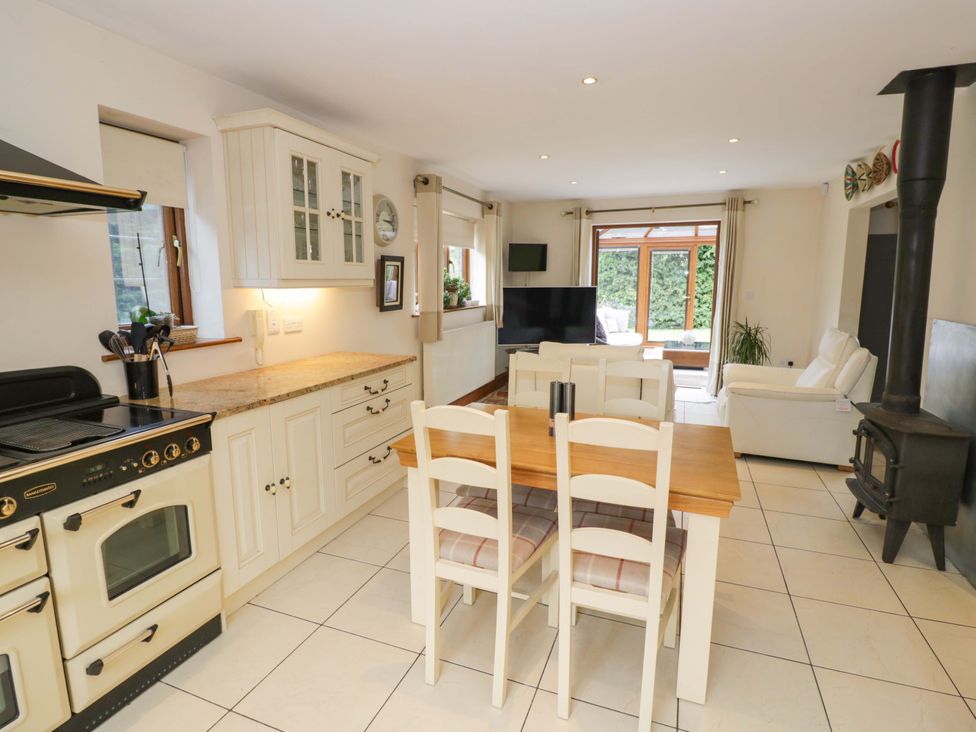 A kitchen with a dining table and chairs at Meadow View Bungalow in Droitwich
