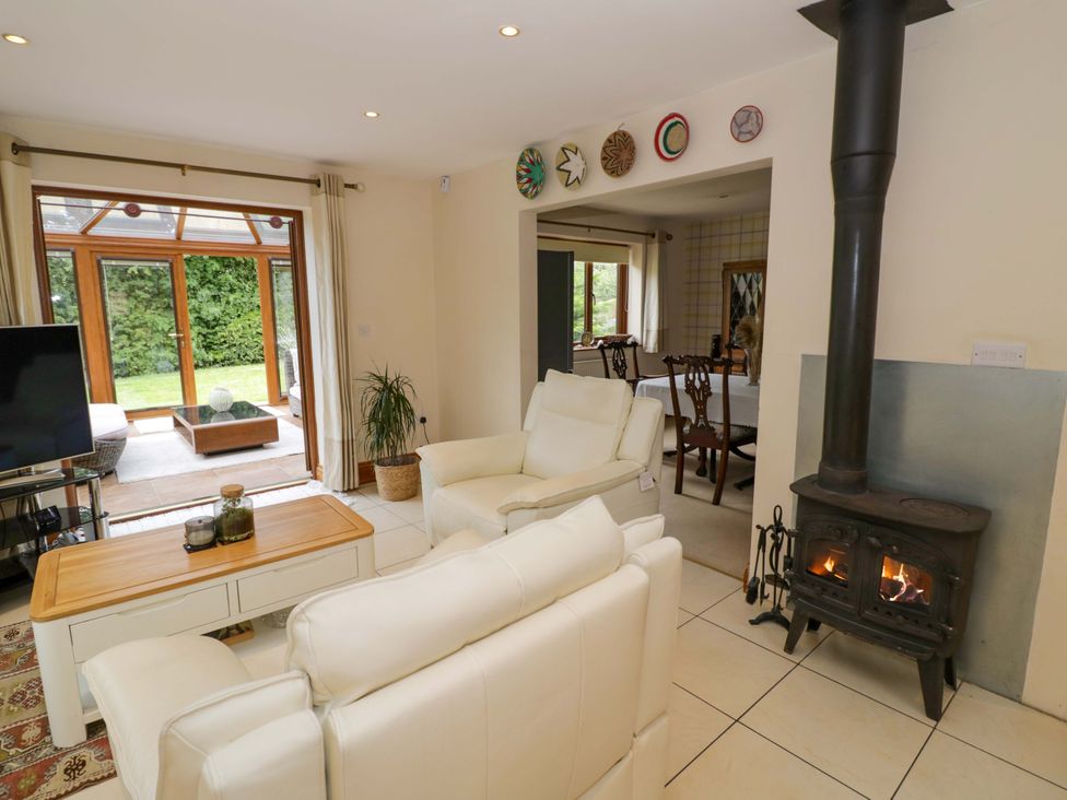 A living room with a sofa and wood stove at Meadow View Bungalow in Droitwich