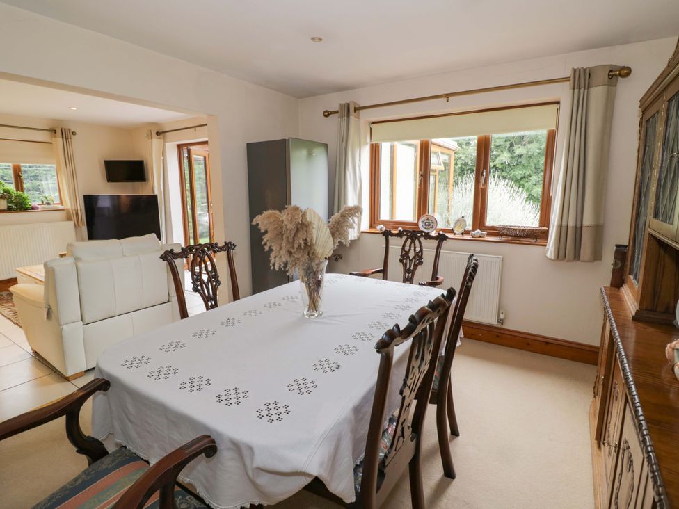 A dining room with a table and chairs at Meadow View Bungalow in Droitwich