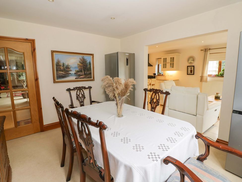 A dining room with a table and chairs at Meadow View Bungalow in Droitwich