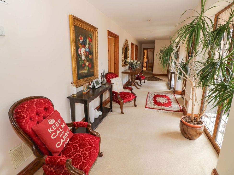 A hallway with red chairs and artwork at Meadow View Bungalow in Droitwich