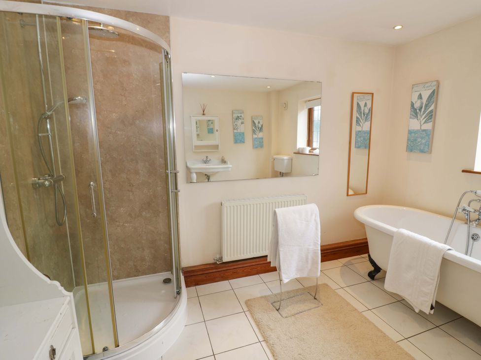 A bathroom with a shower, bathtub, and sink at Meadow View Bungalow in Droitwich